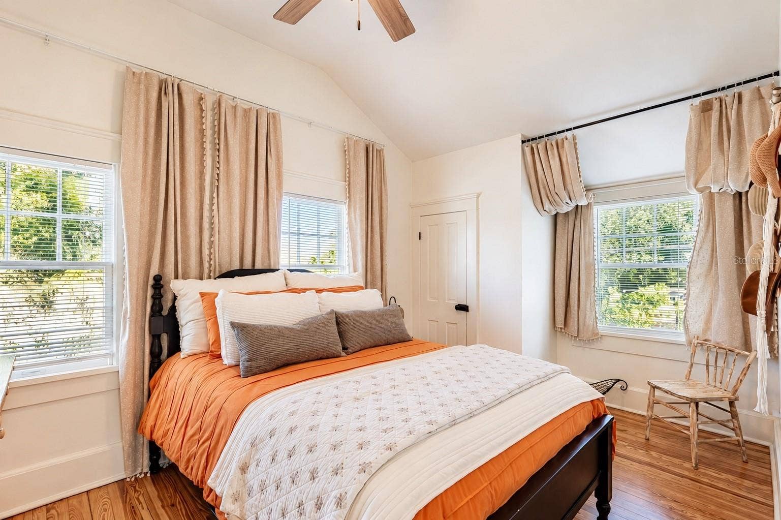1901 10TH STREET, St Cloud, FL 34769 Bright and inviting SECOND BEDROOM UPSTAIRS featuring vaulted ceilings, beautiful wood flooring, abundant natural light, ceiling fan, and a WALK-IN CLOSET.