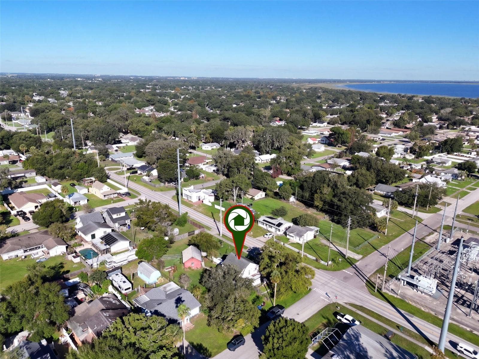 1901 10TH STREET, St Cloud, FL 34769 Aerial view showcasing this charming farmhouse situated on an expansive .34-ACRE CORNER LOT with a FENCED BACKYARD, BARN WITH ELECTRICITY, and an abundance of edible fruit trees, plants, and herbs. Enjoy the beauty of a well-established neighborhood with mature trees and the added bonus of a nearby lake!