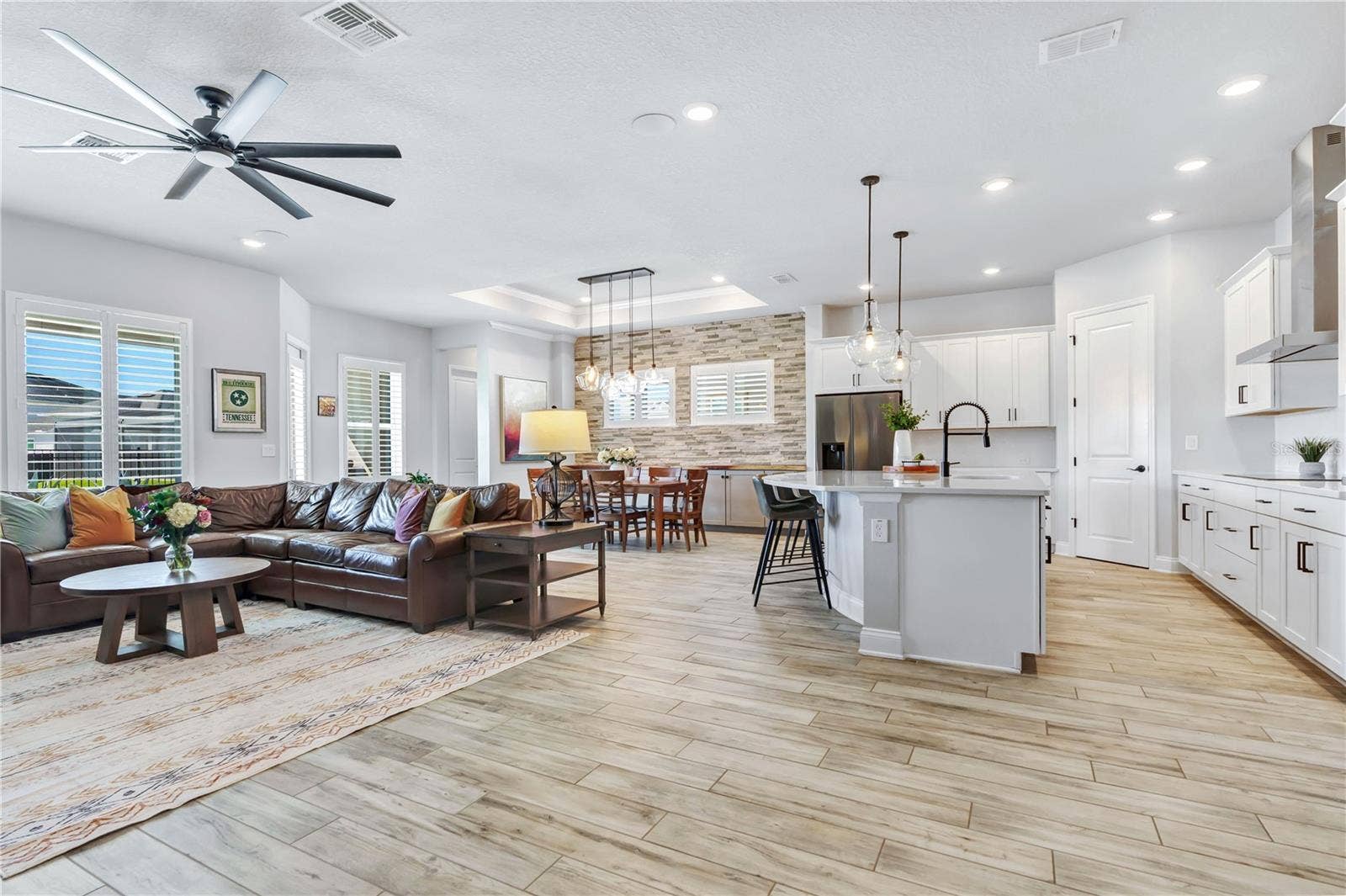 8336 CANETTI STREET, Orlando, FL 32827 Bright great room open to the kitchen with high ceilings, ceiling fan, and plantation shutters. Easy everyday living in Laureate Park, Lake Nona.