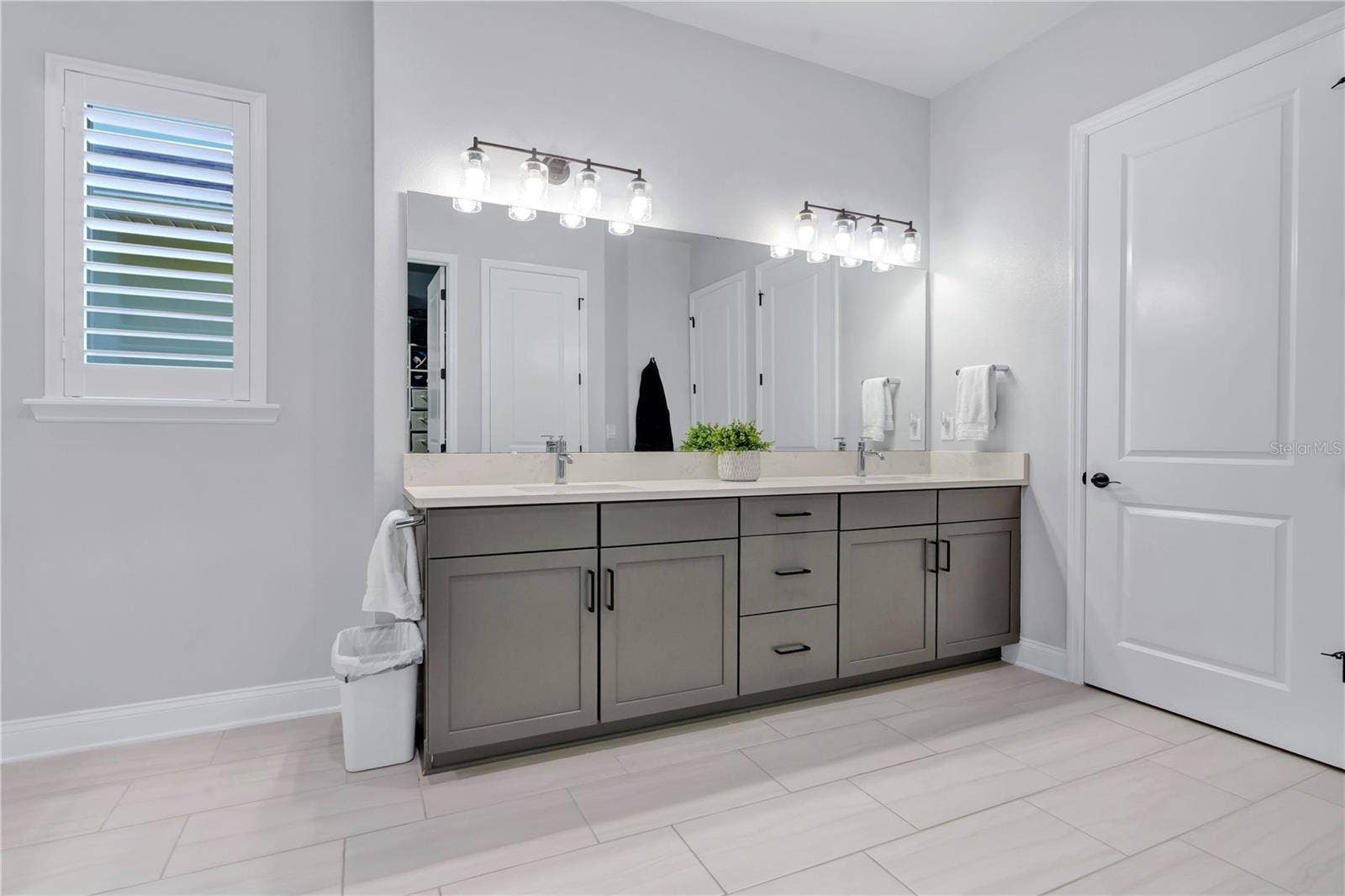8336 CANETTI STREET, Orlando, FL 32827 Primary bath vanity with dual sinks, quartz counters, framed mirrors, and modern lighting.