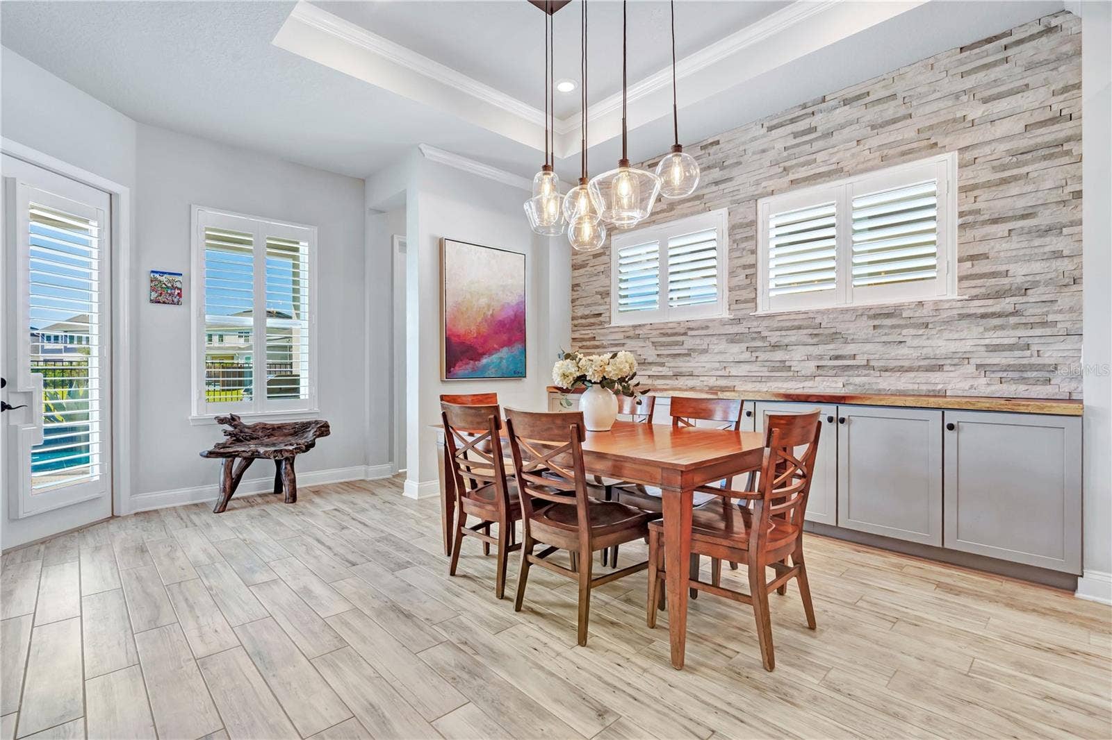 8336 CANETTI STREET, Orlando, FL 32827 Dining space with natural light and stone accent wall, open to the kitchen and living areas.