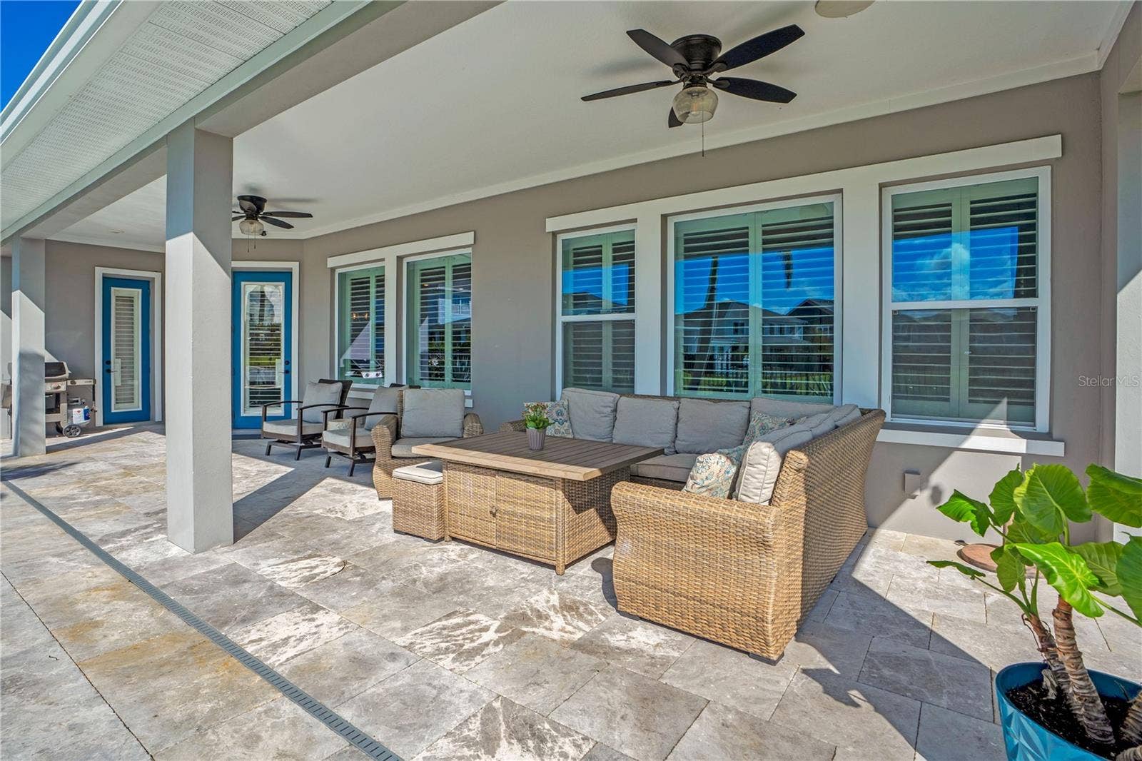 8336 CANETTI STREET, Orlando, FL 32827 Covered lanai lounge with ceiling fan, perfect for relaxing year round in Central Florida.