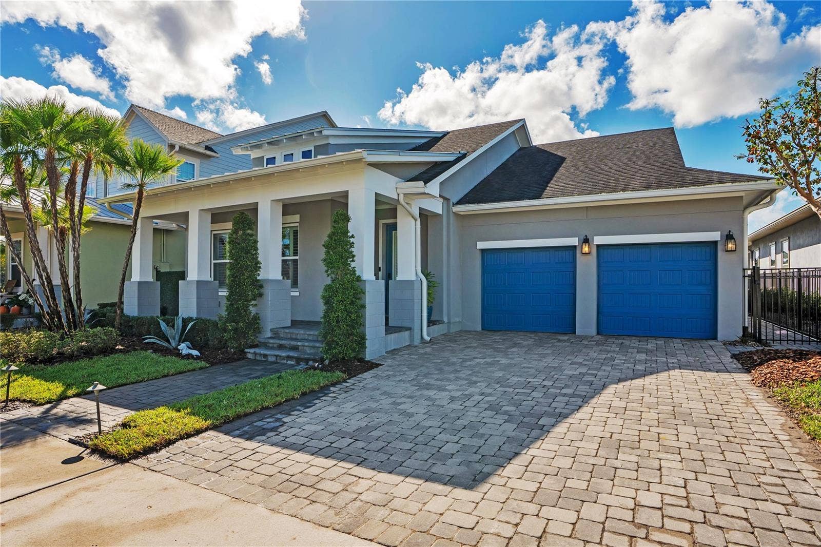 8336 CANETTI STREET, Orlando, FL 32827 Front elevation with paver driveway, two car garage with EV charging, and covered front porch.