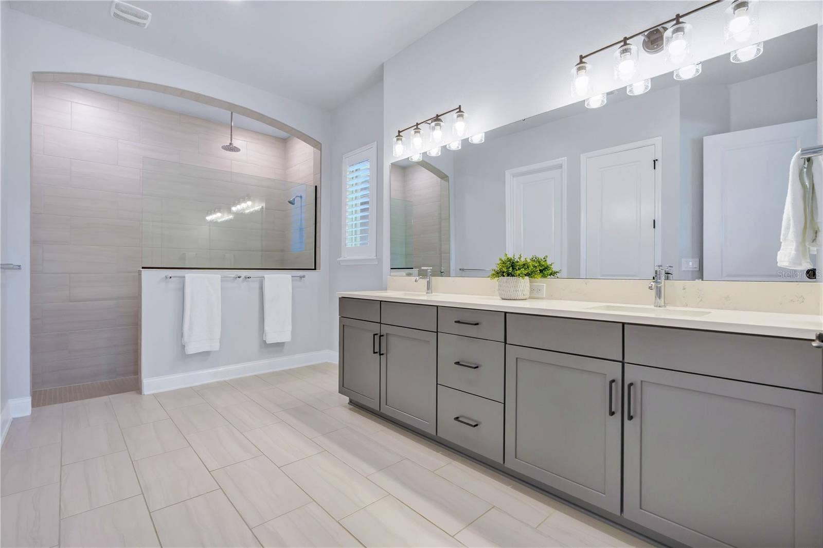 8336 CANETTI STREET, Orlando, FL 32827 Primary bath with a Carrara Marmi quartz double vanity, extra drawer storage, and a large walk in shower.