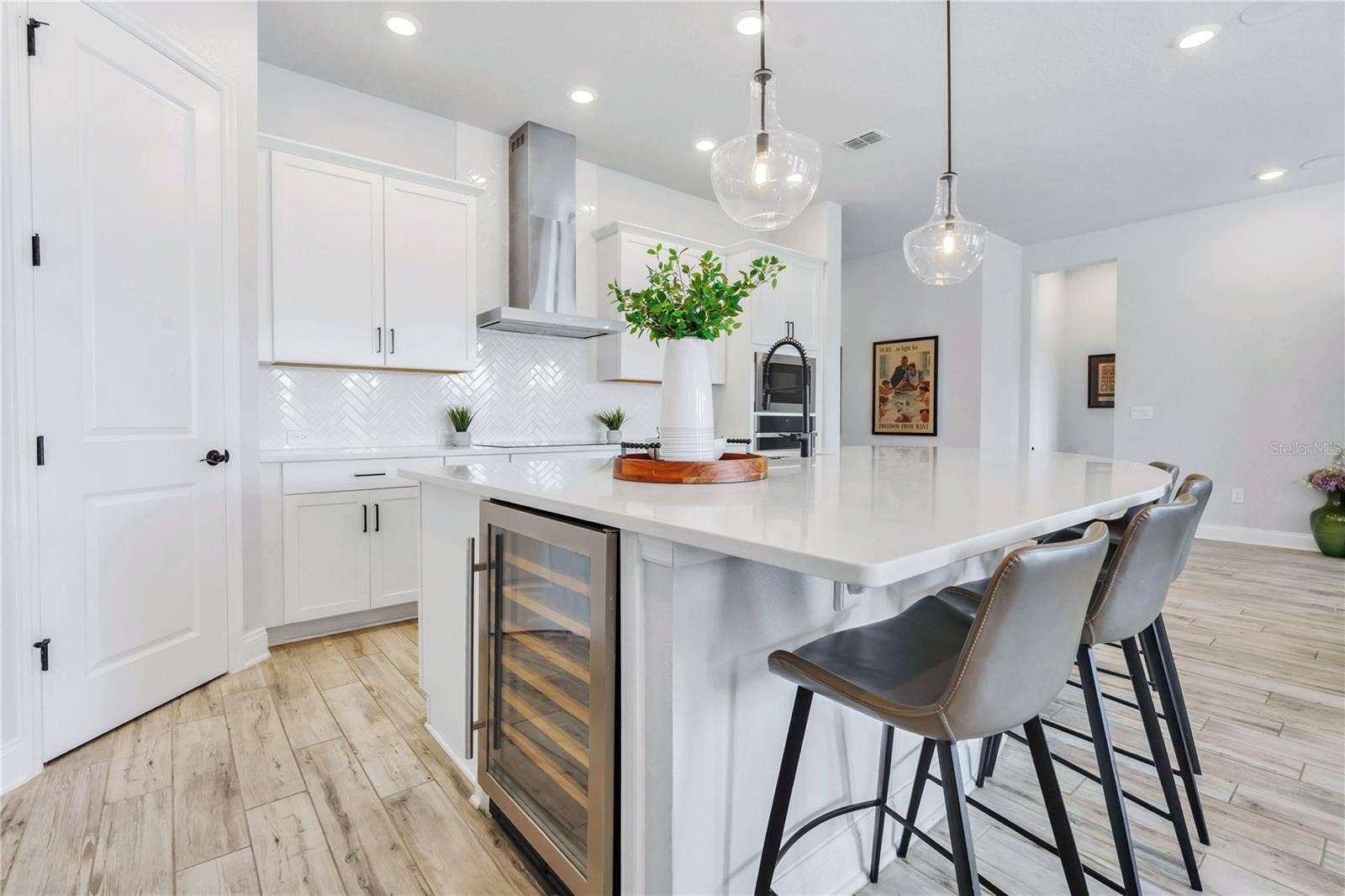 8336 CANETTI STREET, Orlando, FL 32827 Quartz island with built in wine refrigerator, matte black hardware, and counter seating. A true centerpiece for hosting.
