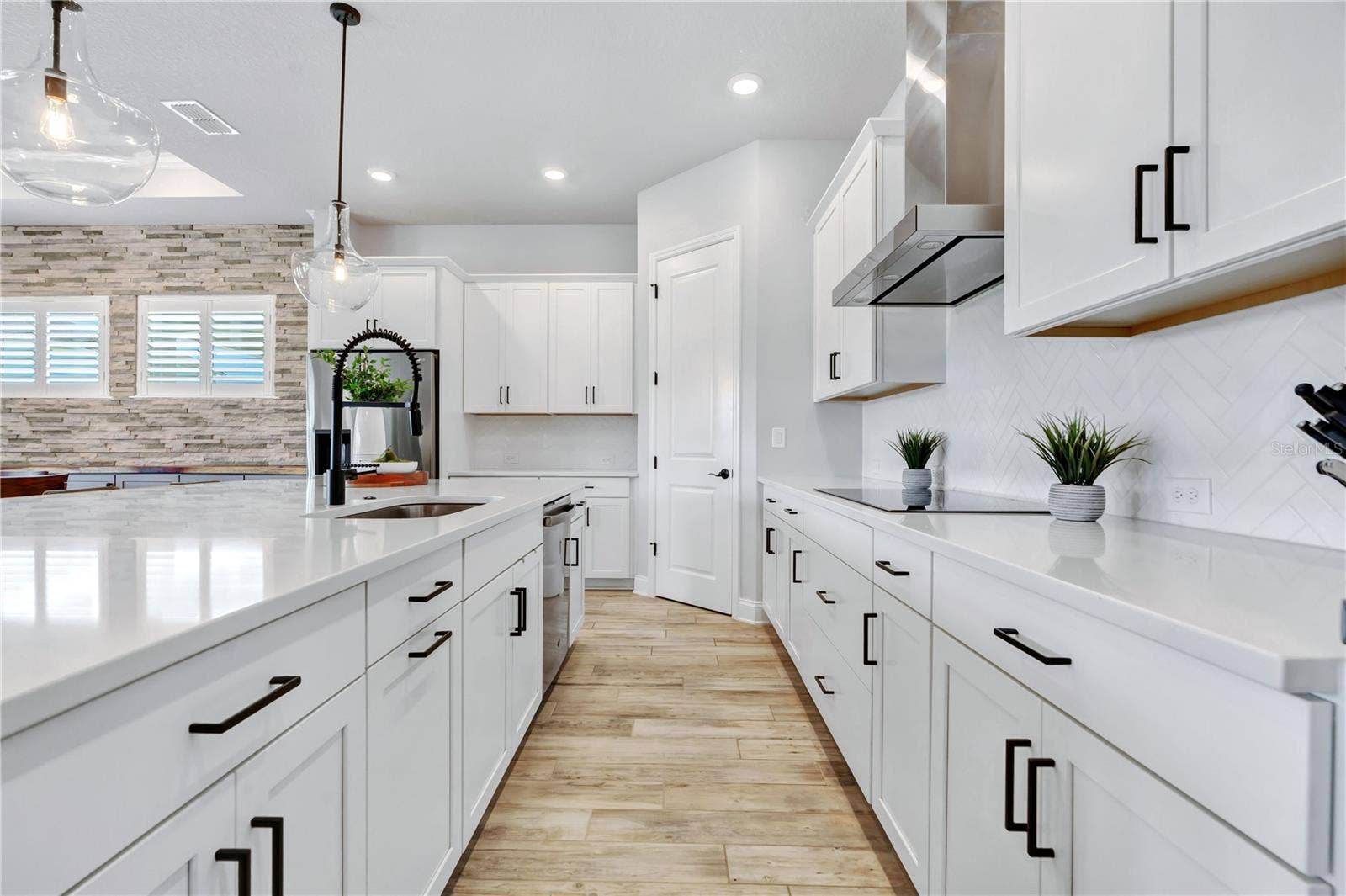 8336 CANETTI STREET, Orlando, FL 32827 White 42 inch cabinetry, stainless range hood, and herringbone backsplash. Abundant storage plus a walk in pantry.