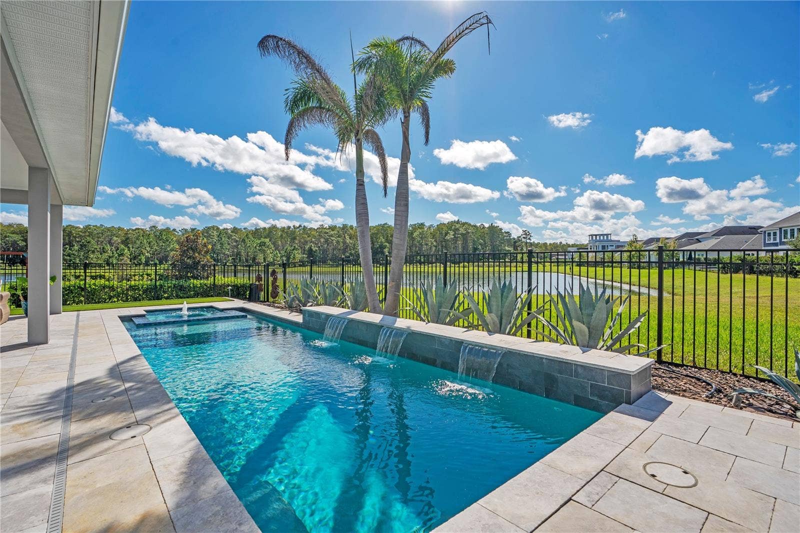 8336 CANETTI STREET, Orlando, FL 32827 Private heated salt water pool framed by palms and a fenced yard with a water and conservation view. Lake Nona pool home living in Laureate Park, Orlando.