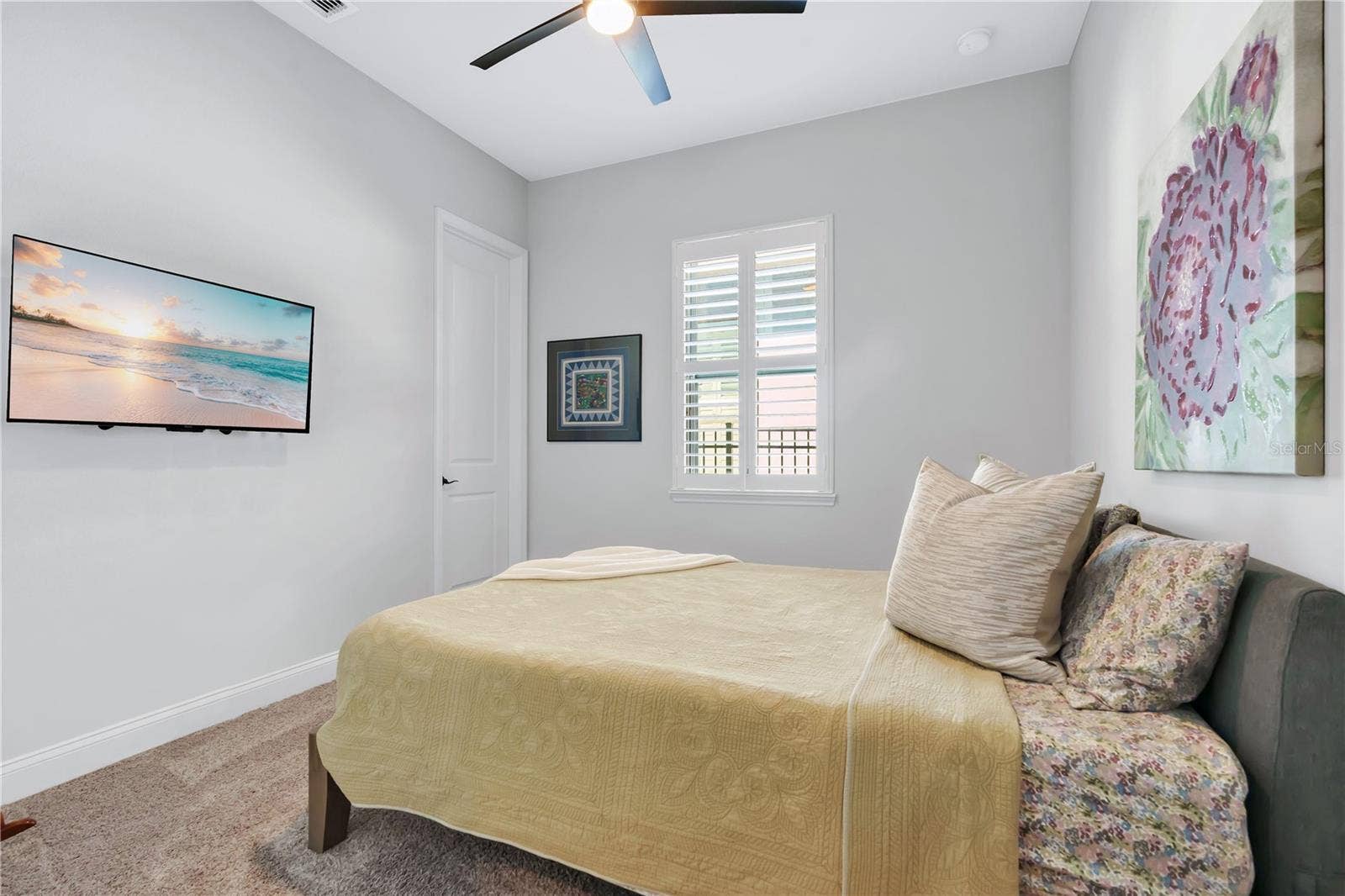 8336 CANETTI STREET, Orlando, FL 32827 Secondary bedroom with ceiling fan, carpet, and natural light.
