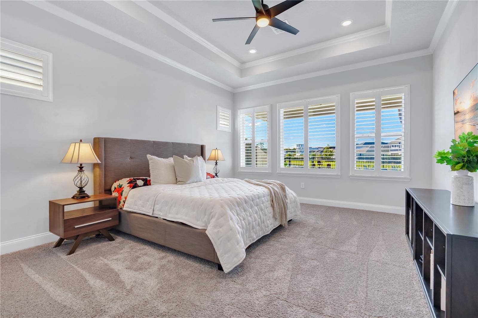 8336 CANETTI STREET, Orlando, FL 32827 Primary bedroom with a tray ceiling and plenty of natural light, privately positioned in the split bedroom floor plan.
