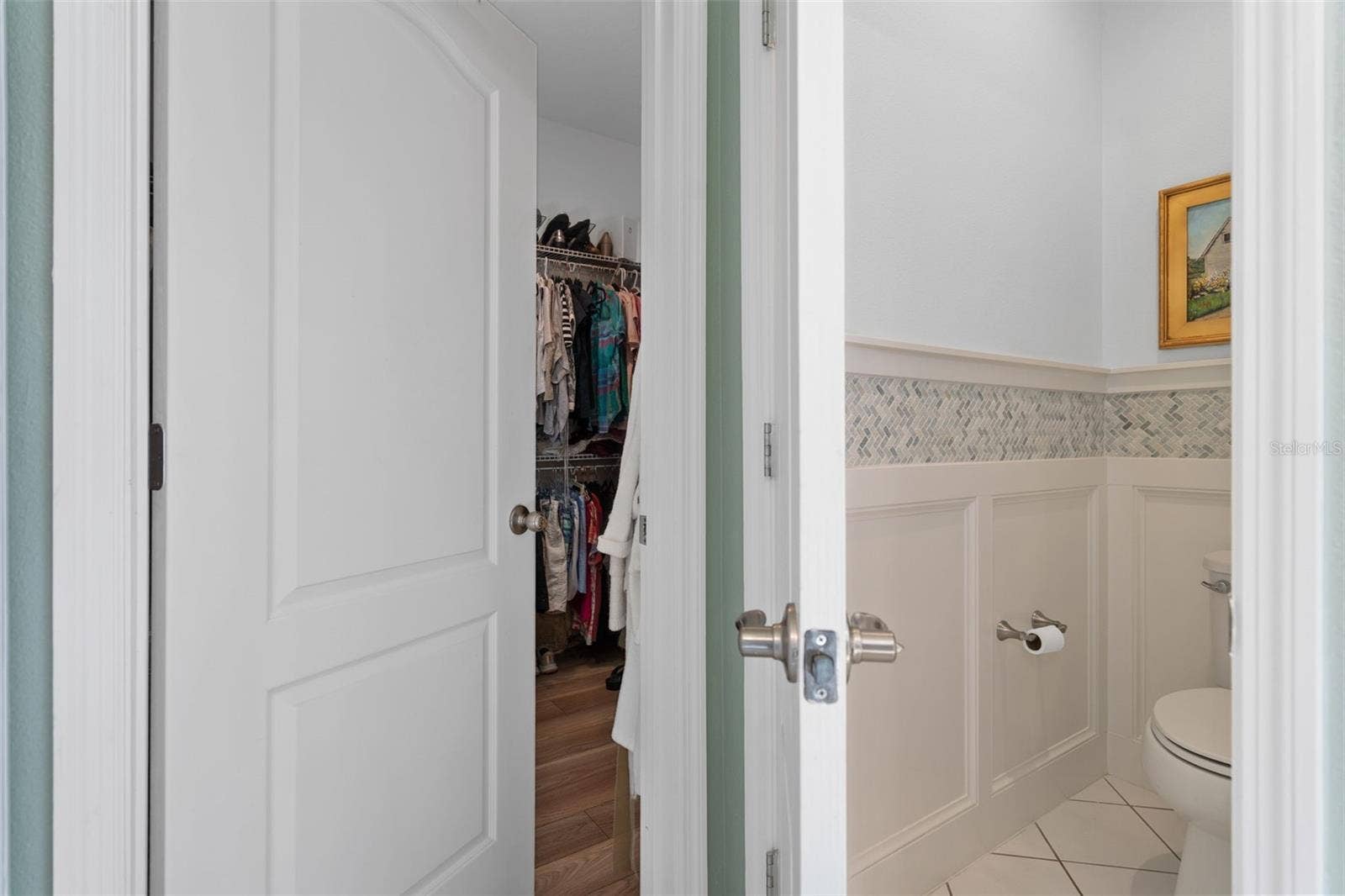 1038 TIMBERVALE TRAIL, Clermont, FL 34715 The Primary En-Suite Water Closet offers a Custom Wall Treatment. The walk-in Closet offers plenty of space and LVP flooring.