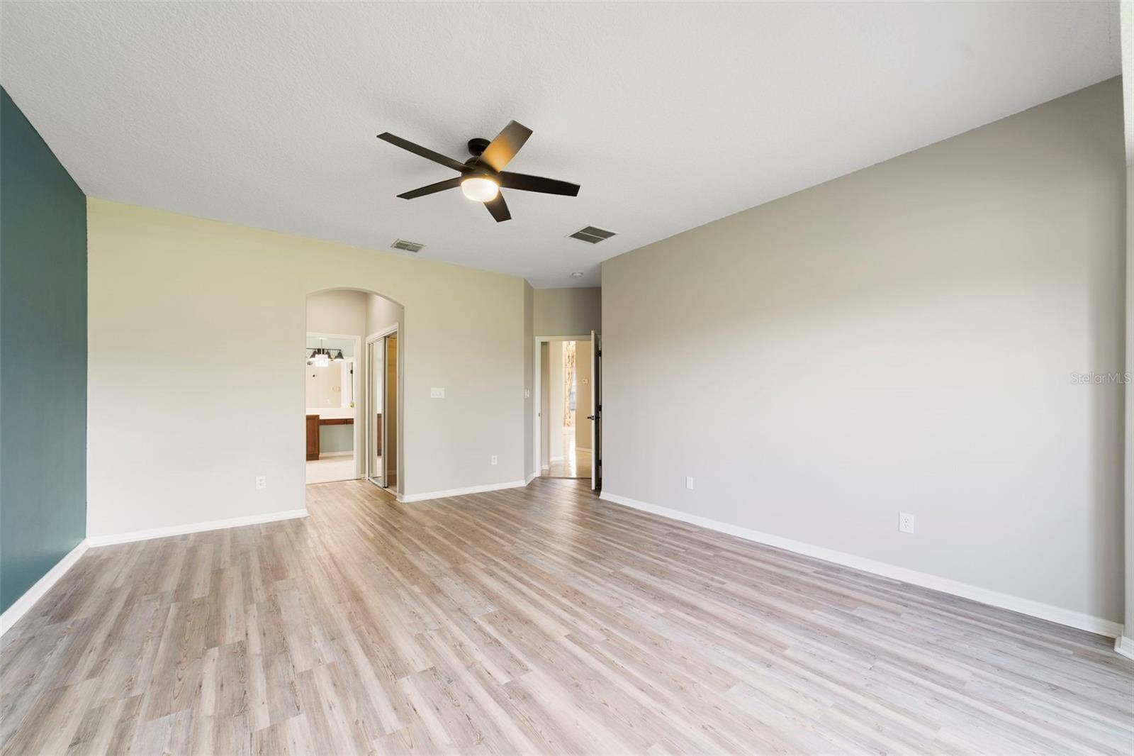 1557 AMARYLLIS CIRCLE, Orlando, FL 32825 The FIRST-FLOOR PRIMARY SUITE presents a private retreat with LVP FLOORING and a bay window that fills the room with NATURAL LIGHT.