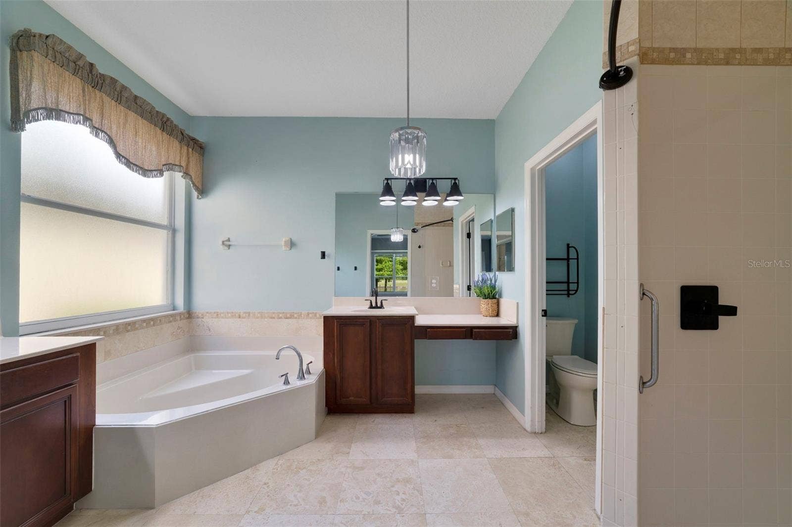 1557 AMARYLLIS CIRCLE, Orlando, FL 32825 The Primary en suite Bath features dual vanities, a RELAXING GARDEN TUB, a step-in shower and a private water closet.