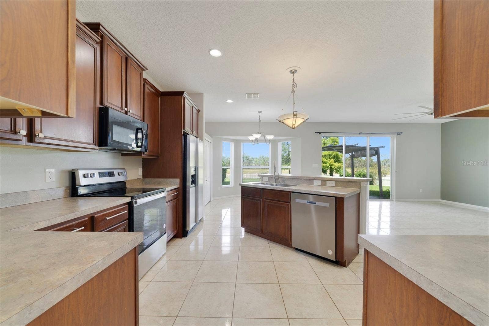 1557 AMARYLLIS CIRCLE, Orlando, FL 32825 A center island with breakfast bar offers plenty of room for meal preparation and gathering.