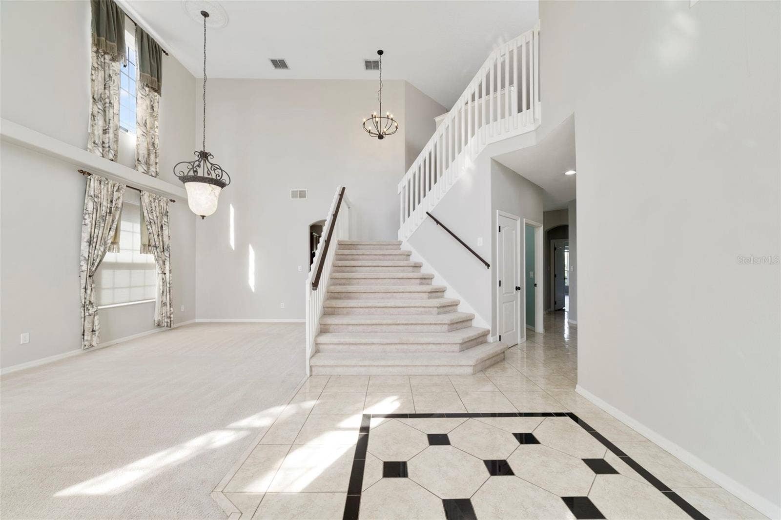 1557 AMARYLLIS CIRCLE, Orlando, FL 32825 Inside, ETCHED-GLASS FRENCH DOORS open to a welcoming foyer with a SOARING CEILING and decorative tile flooring, setting the stage for the generous living spaces beyond.