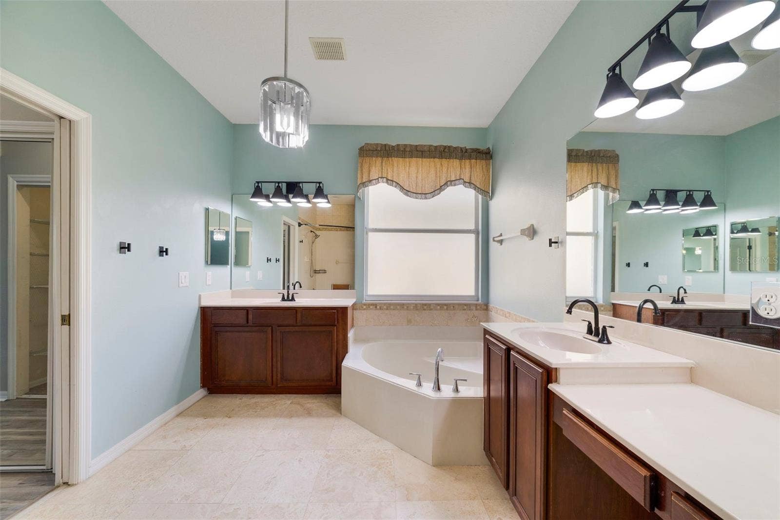 1557 AMARYLLIS CIRCLE, Orlando, FL 32825 The Primary en suite Bath features dual vanities, a RELAXING GARDEN TUB, a step-in shower and a private water closet.