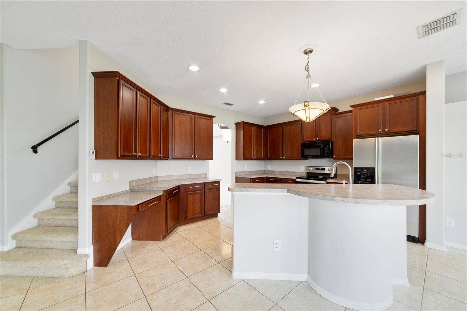 1557 AMARYLLIS CIRCLE, Orlando, FL 32825 A center island with breakfast bar offers plenty of room for meal preparation and gathering.