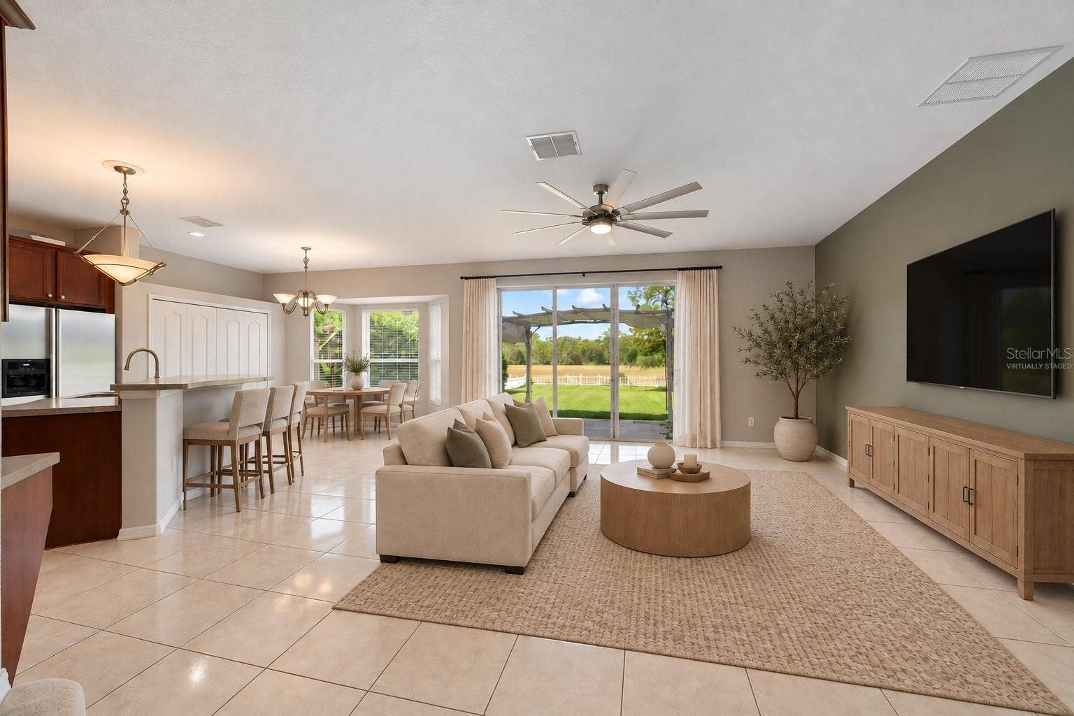 1557 AMARYLLIS CIRCLE, Orlando, FL 32825 The Kitchen flows seamlessly into the Family Room, where triple sliding glass doors bring in NATURAL LIGHT and open to the back patio, extending the living space outdoors. Virtually Staged