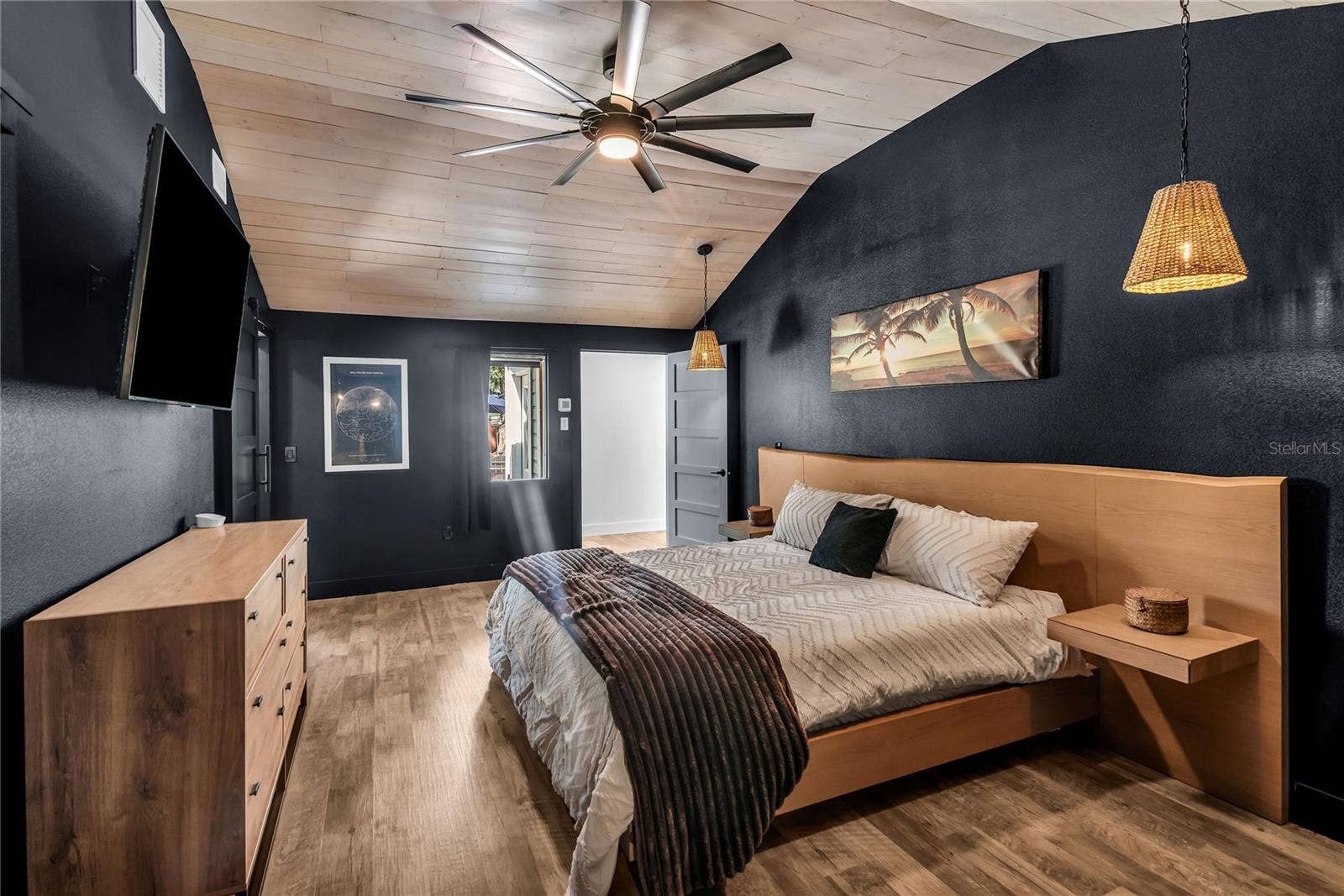 234 N LAKEVIEW AVENUE, Winter Garden, FL 34787 The secluded primary suite blends modern design with inviting comfort, showcasing a striking vaulted plank ceiling, stylish pendant lighting, and an expansive layout. Thoughtfully positioned for privacy, this retreat feels both intimate and spacious, with warm wood accents and sophisticated finishes creating a refined yet relaxing atmosphere.