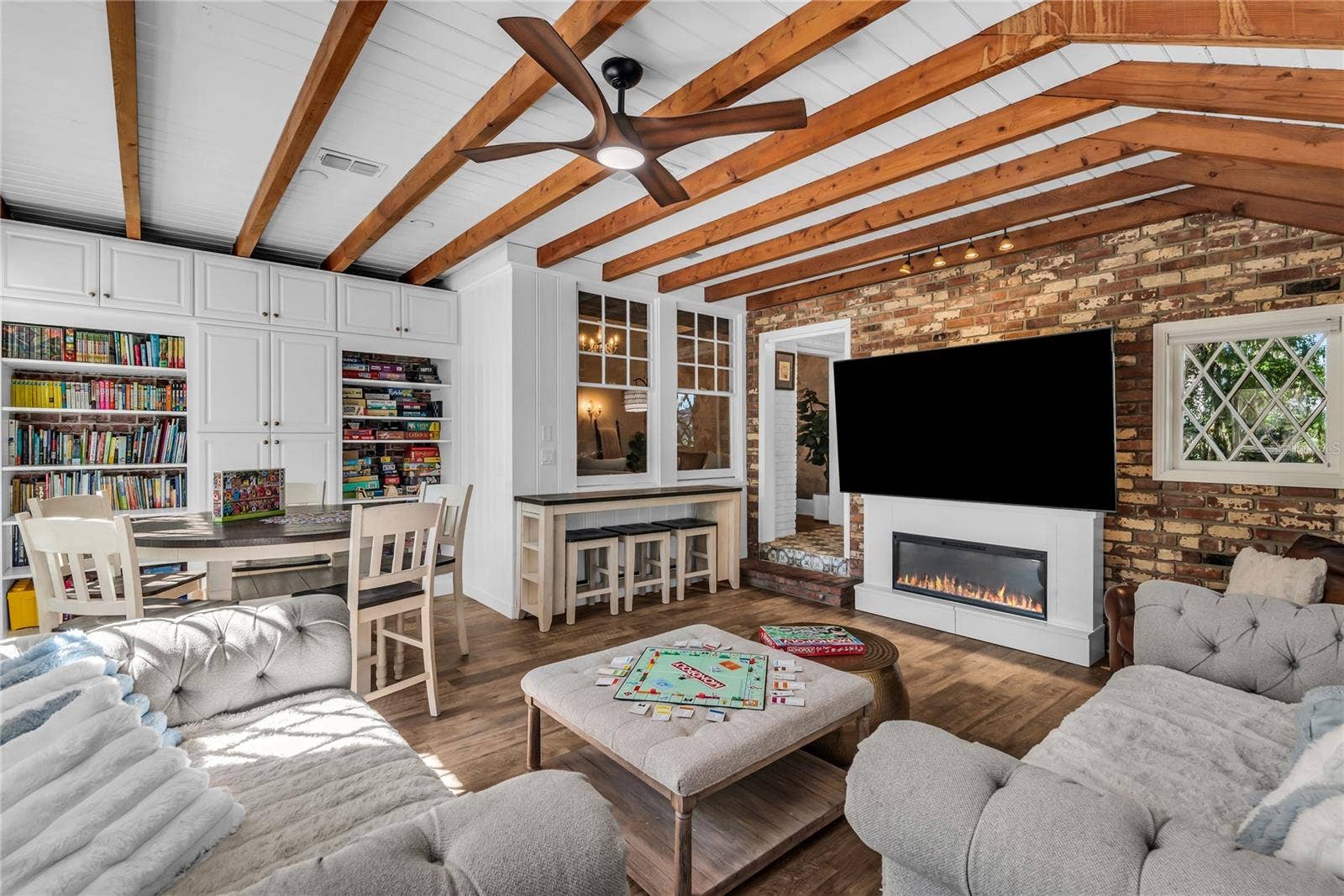 234 N LAKEVIEW AVENUE, Winter Garden, FL 34787 Natural light pours into the spacious family room that features warm brick walls, exposed wood beams and distinctive diamond-pane windows that create a timeless architectural backdrop.
