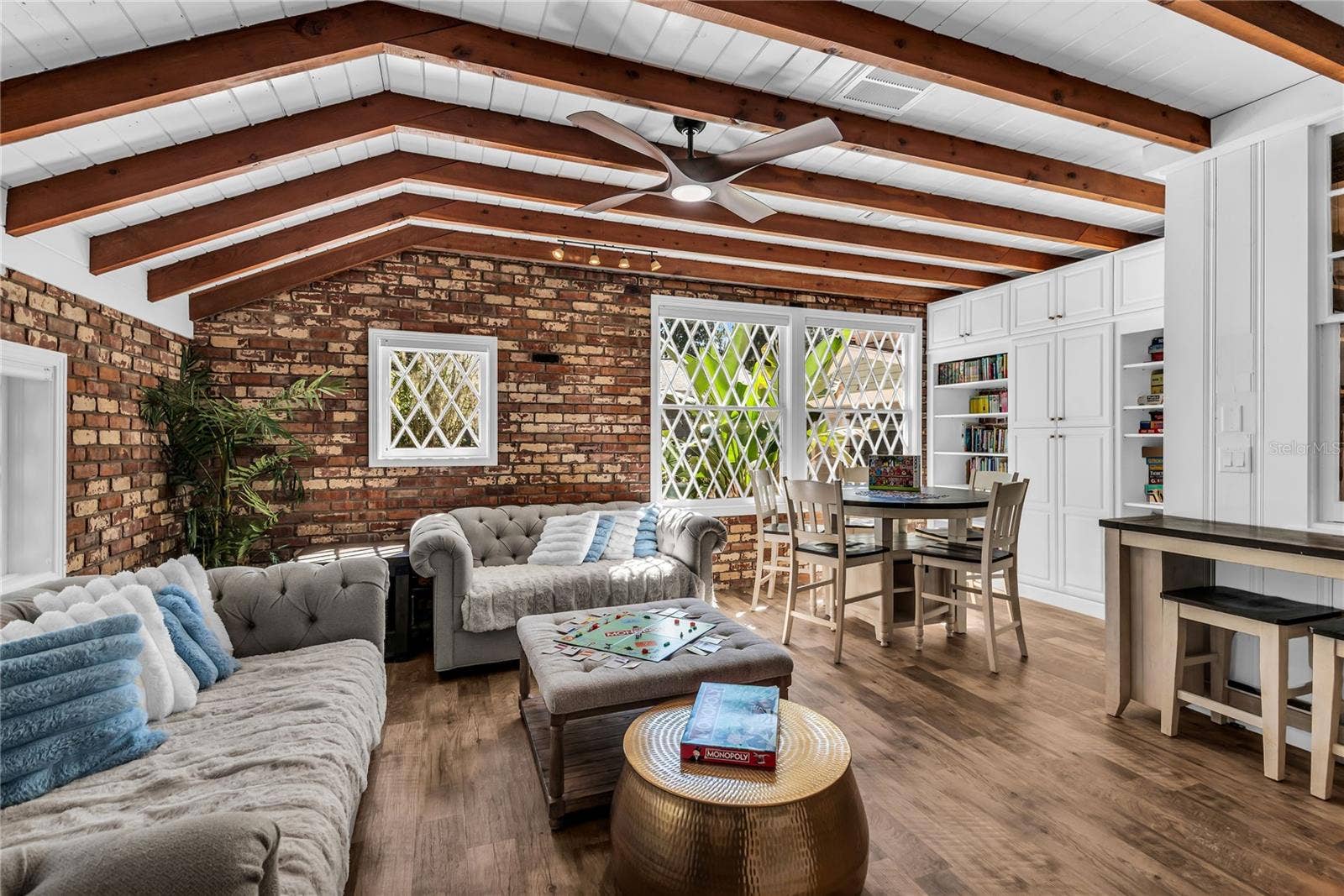 234 N LAKEVIEW AVENUE, Winter Garden, FL 34787 Natural light pours into the spacious family room that features warm brick walls, exposed wood beams and distinctive diamond-pane windows that create a timeless architectural backdrop.