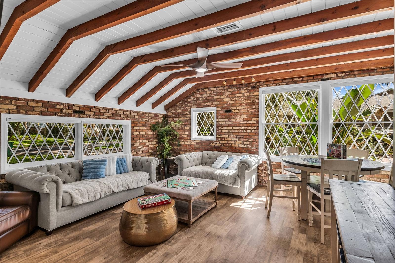 234 N LAKEVIEW AVENUE, Winter Garden, FL 34787 Natural light pours into the spacious family room that features warm brick walls, exposed wood beams and distinctive diamond-pane windows that create a timeless architectural backdrop.