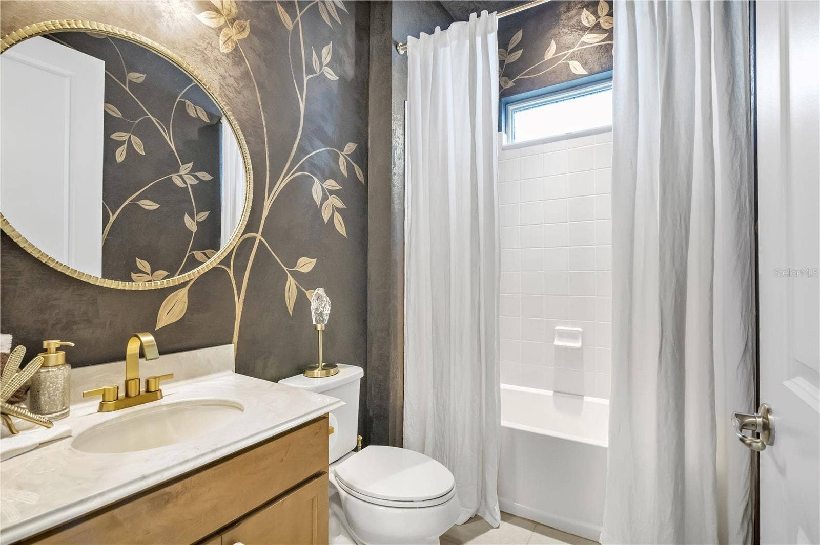 15749 CUTTER SAIL PLACE, Winter Garden, FL 34787 Beautifully styled bathroom featuring decorative wall finishes and elegant gold accents.