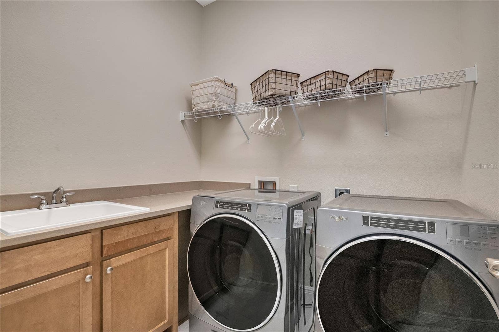 15749 CUTTER SAIL PLACE, Winter Garden, FL 34787 Spacious laundry room with utility sink, cabinetry, and convenient storage.