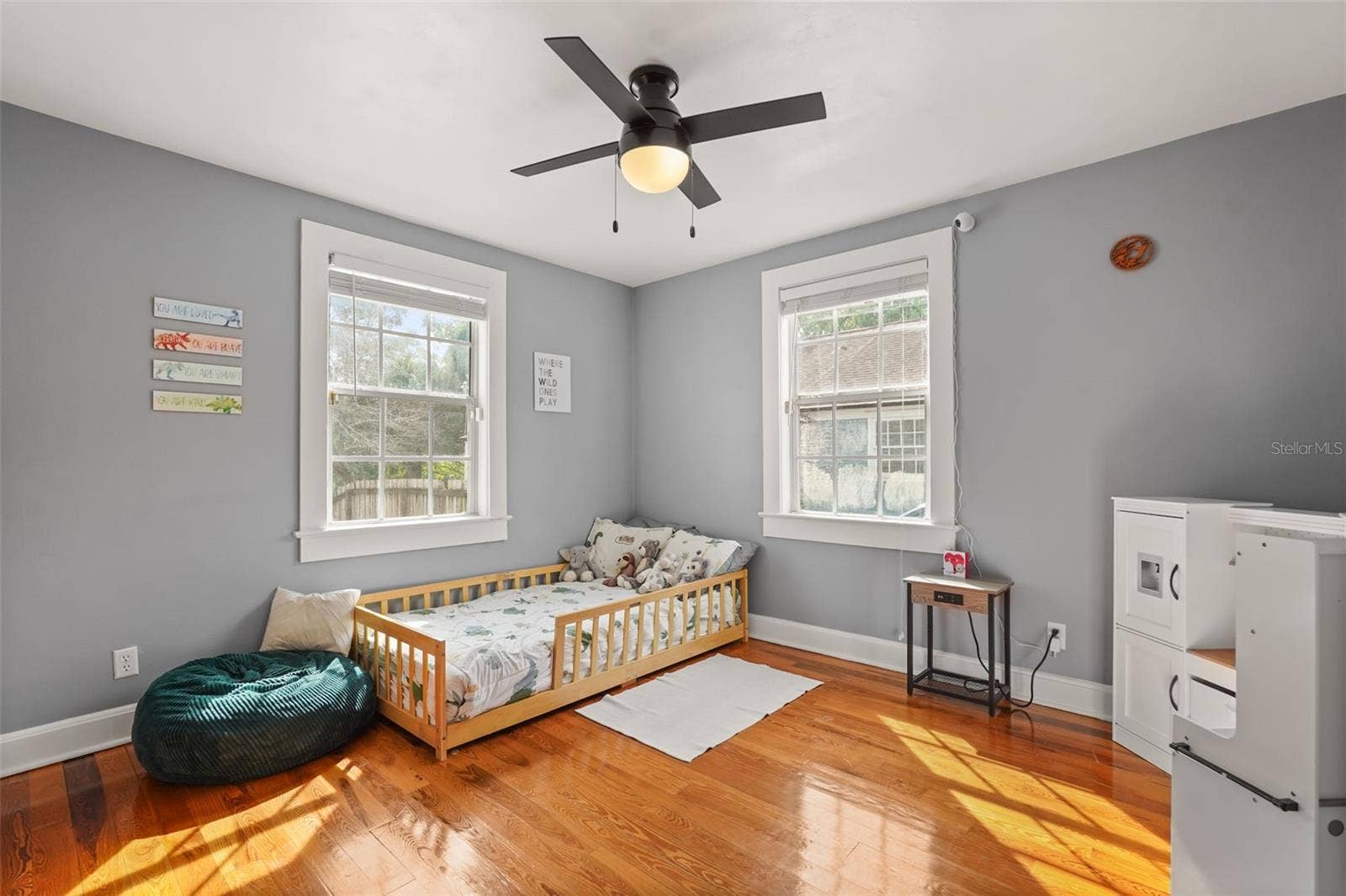 Bedroom with two windows and wood floors