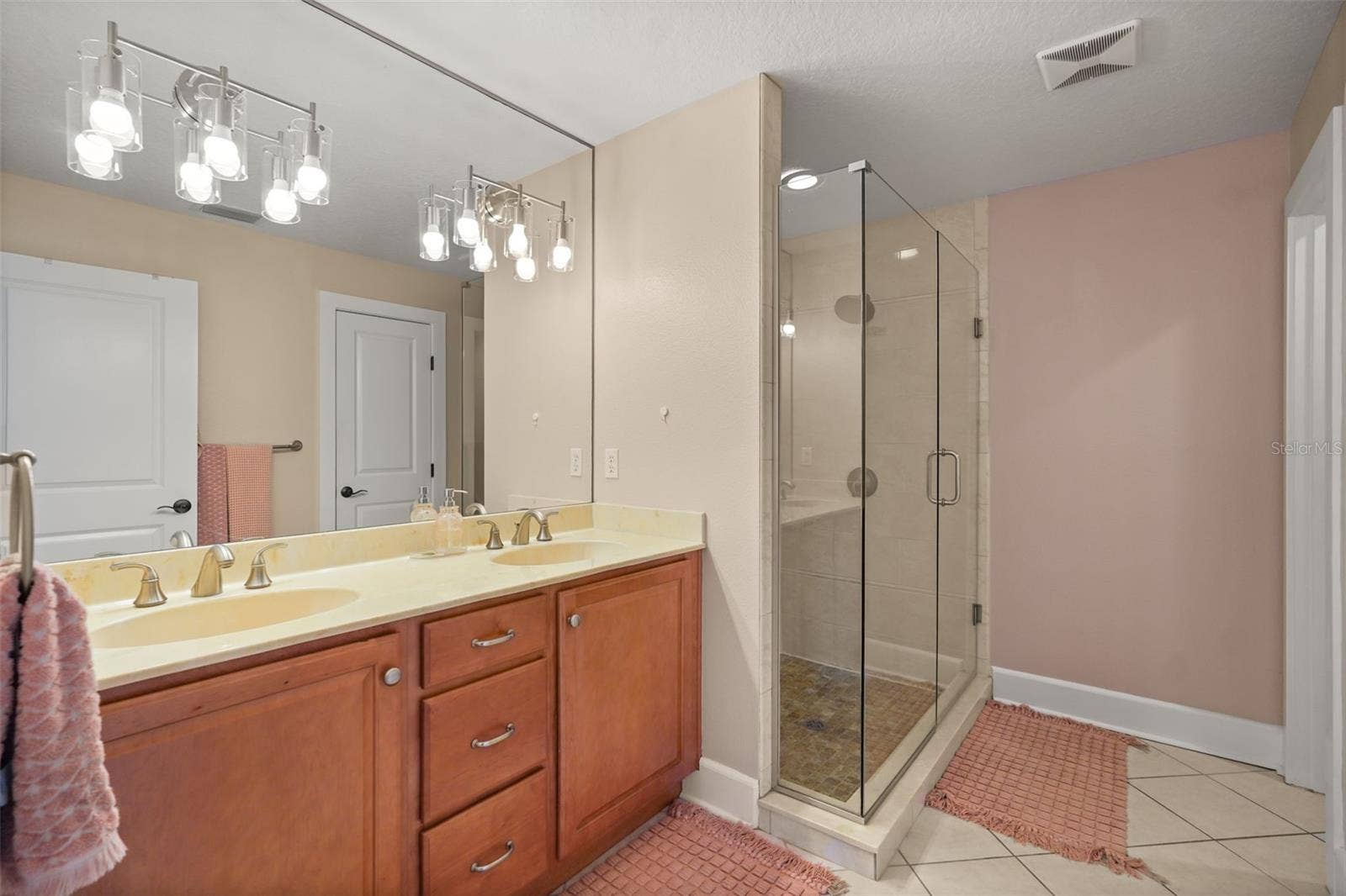 Primary bathroom with dual vanity and glass-enclosed shower