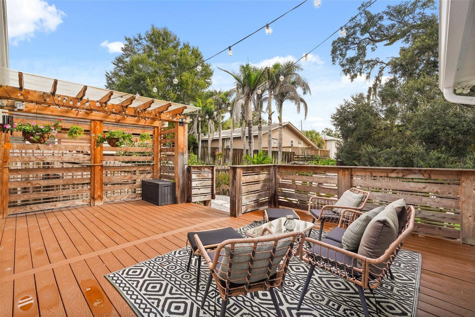 Rear deck seating area with pergola and string lights