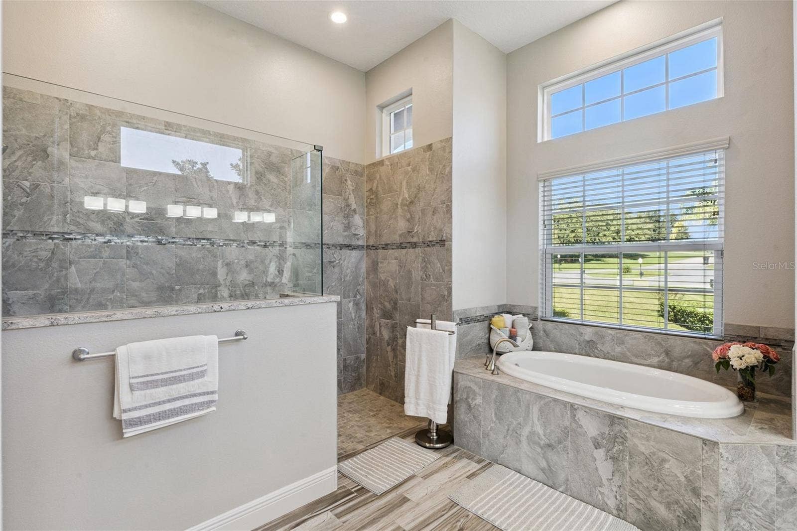 36819 WOLF COURT, Eustis, FL 32736 Spacious master en suite featuring a luxurious, zero-entry walk-in shower and a deep soaking tub for ultimate relaxation.