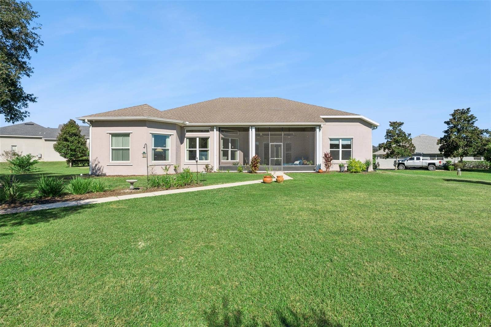 36819 WOLF COURT, Eustis, FL 32736 Rear exterior view featuring a paver walkway leading to the water.