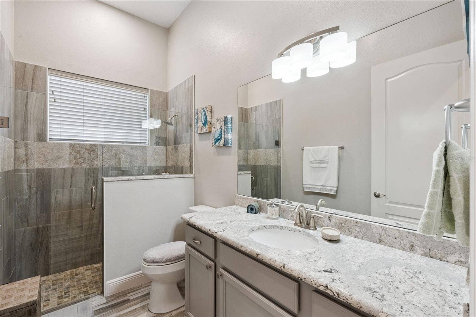 36819 WOLF COURT, Eustis, FL 32736 Bathroom 2, situated between bedrooms 2 and 3, features quartz countertops and a zero-entry walk-in shower.