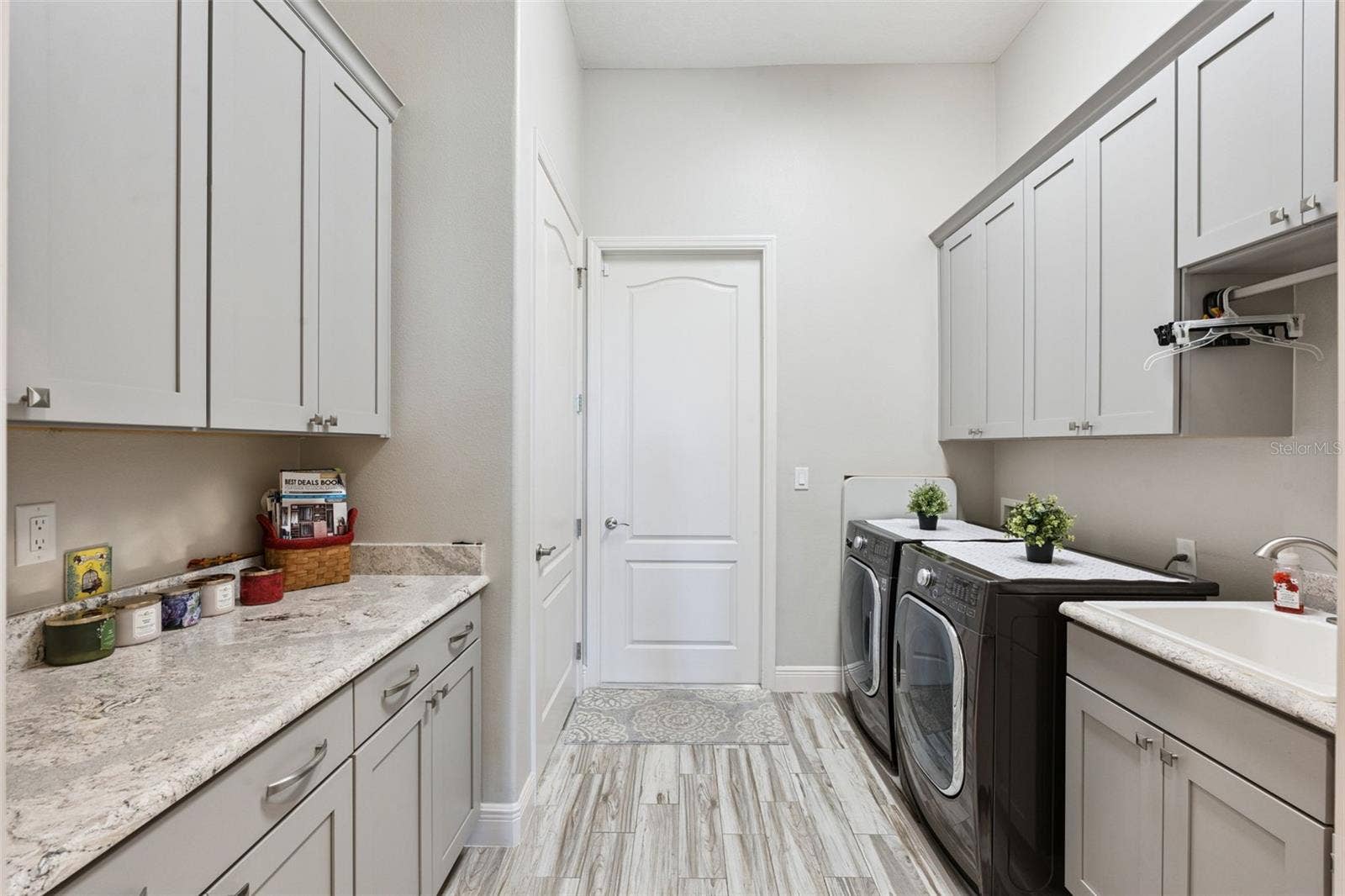 36819 WOLF COURT, Eustis, FL 32736 Bright, functional laundry room featuring ample custom cabinetry, a dedicated folding station with a generous quartz countertop, and an undermount utility sink.
