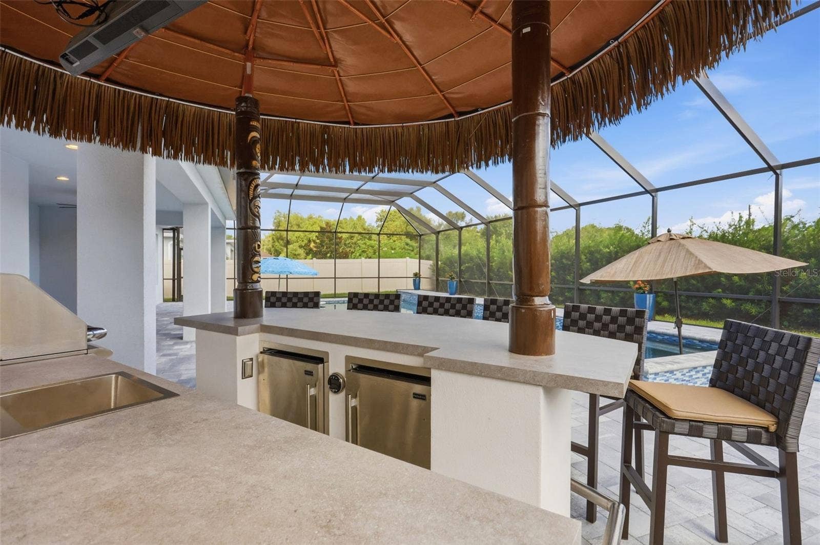 1552 MYRTLE OAKS TRAIL, Oviedo, FL 32765 Summer kitchen includes a grill, two refrigerators, large entertaining bar, and remote pull down TV