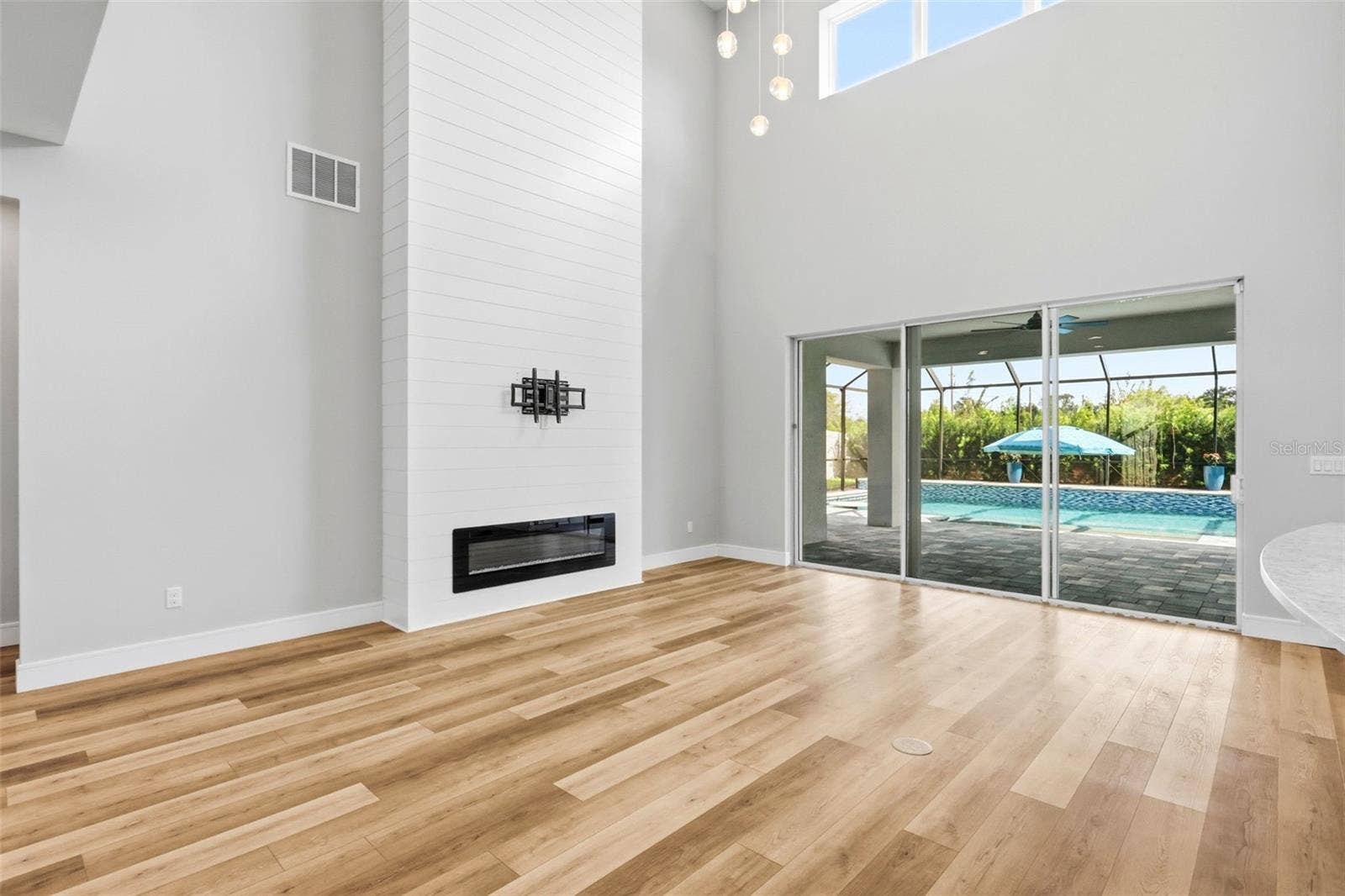 1552 MYRTLE OAKS TRAIL, Oviedo, FL 32765 Soaring ceilings the the living area with sliding doors out to the covered lanai and enclosed pool.