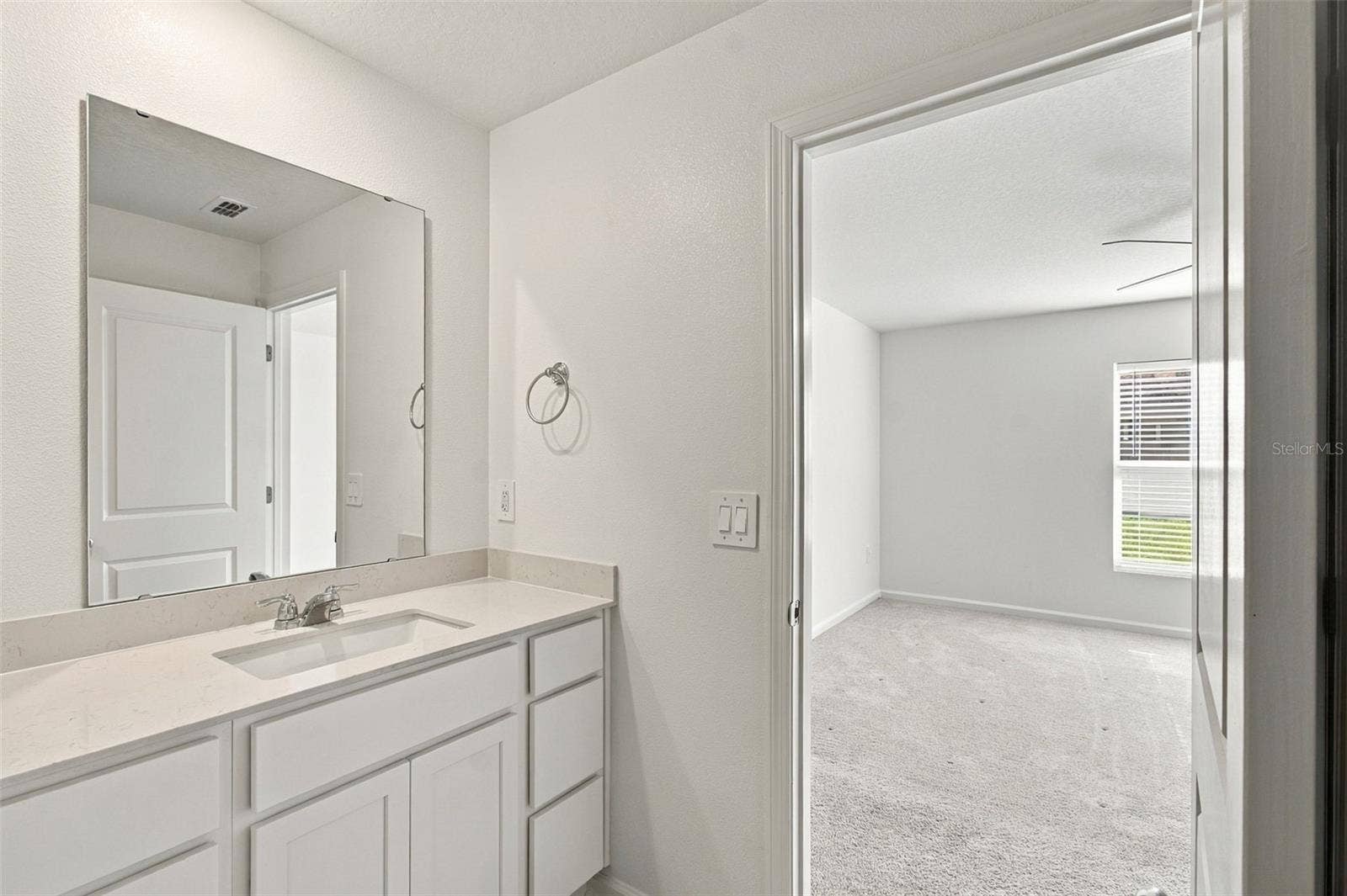 The private owners suite is tucked away at the back of the home and features an en-suite bathroom with dual sinks, a walk-in shower, and a generous walk-in closet.