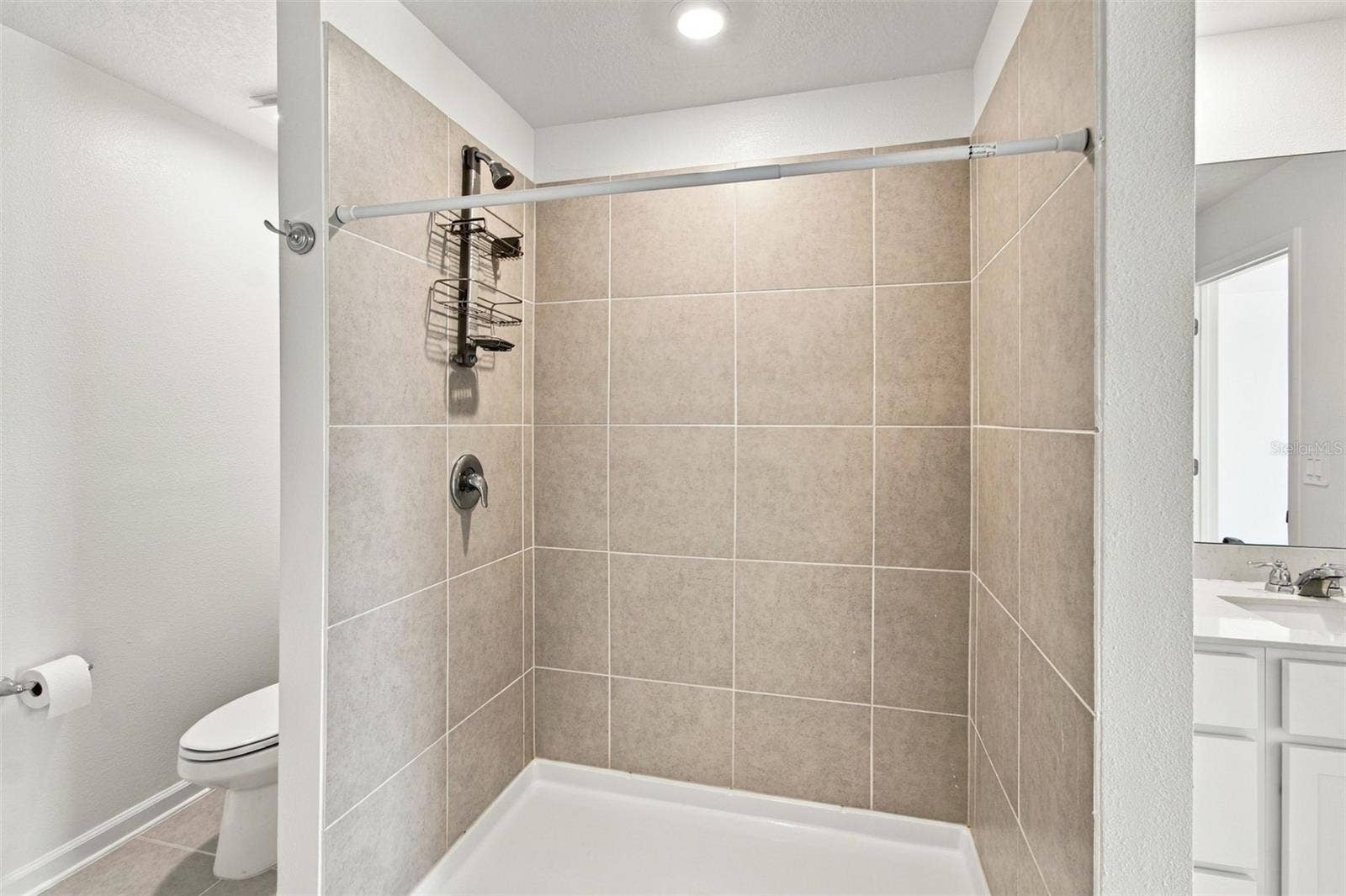 The private owners suite is tucked away at the back of the home and features an en-suite bathroom with dual sinks, a walk-in shower, and a generous walk-in closet.