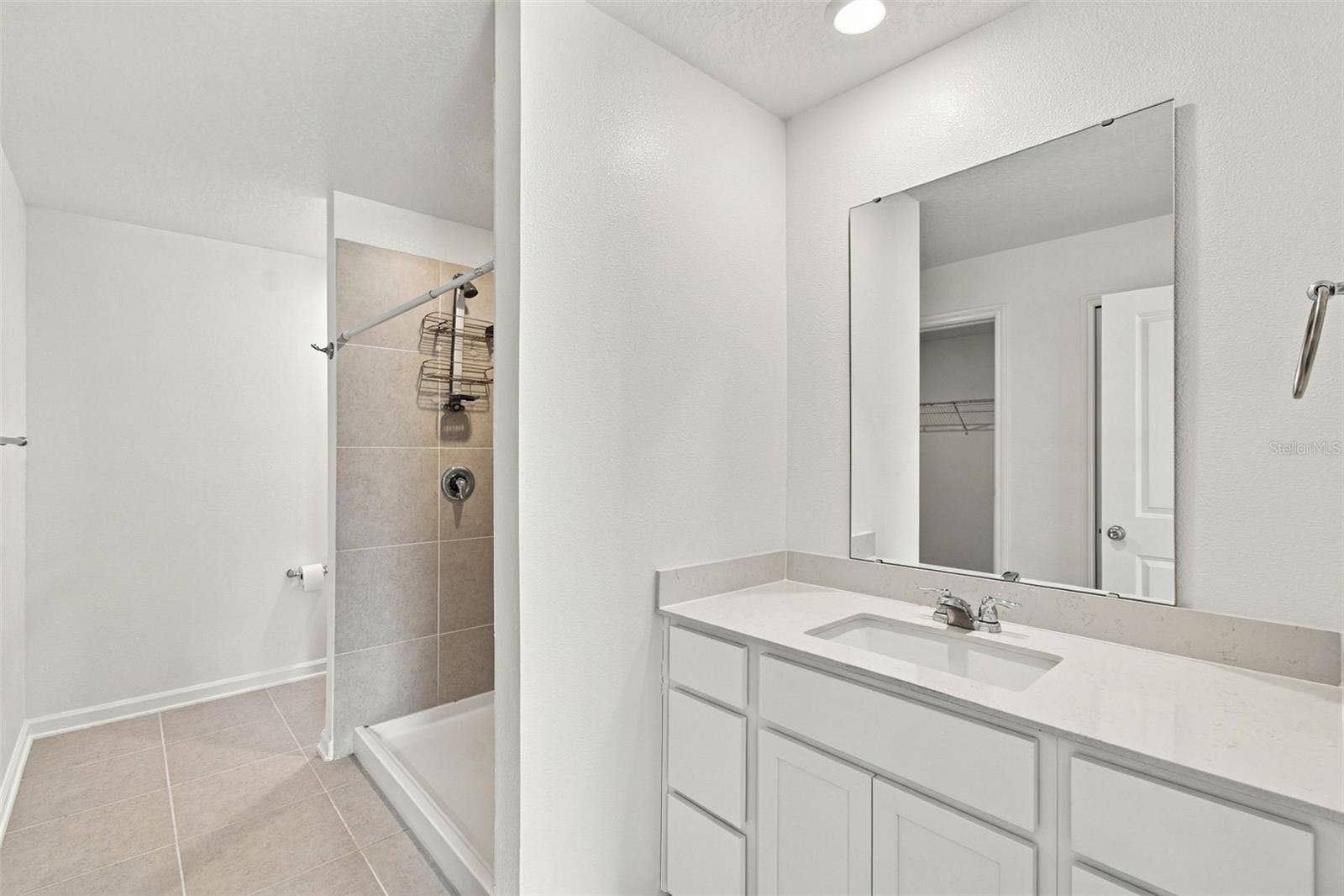 The private owners suite is tucked away at the back of the home and features an en-suite bathroom with dual sinks, a walk-in shower, and a generous walk-in closet.