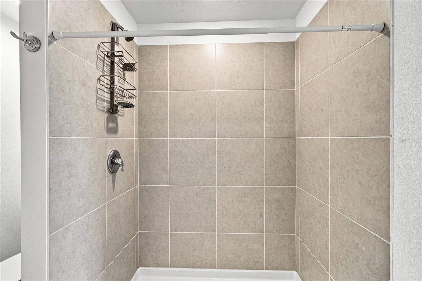 The private owners suite is tucked away at the back of the home and features an en-suite bathroom with dual sinks, a walk-in shower, and a generous walk-in closet.