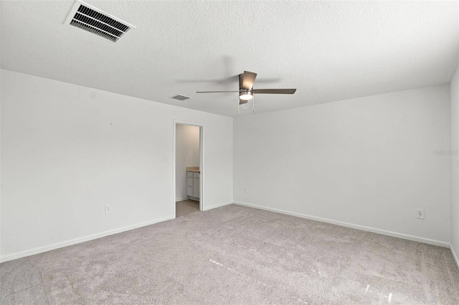 The private owners suite is tucked away at the back of the home and features an en-suite bathroom with dual sinks, a walk-in shower, and a generous walk-in closet.