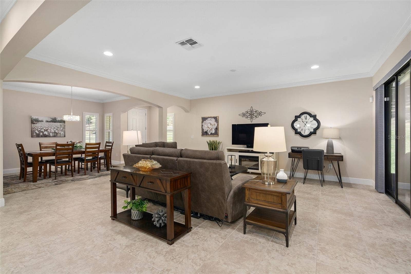 2607 CLEMSON RIDGE COURT, Clermont, FL 34715 Family and Dining Rooms featuring Architectural Arches and Upgraded Ceramic Tile flooring. There is a Floor Electrical Receptacle in the Family Room for your convenience.