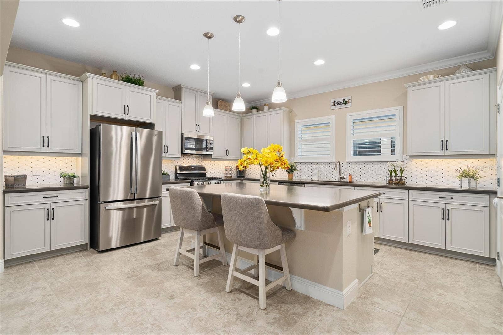 2607 CLEMSON RIDGE COURT, Clermont, FL 34715 What a Beautiful Kitchen with a Natural Stone Backsplash, Pendant Lighting, Quartz Countertops, Upgraded Stainless Steel Appliances and Plantation Shutters.