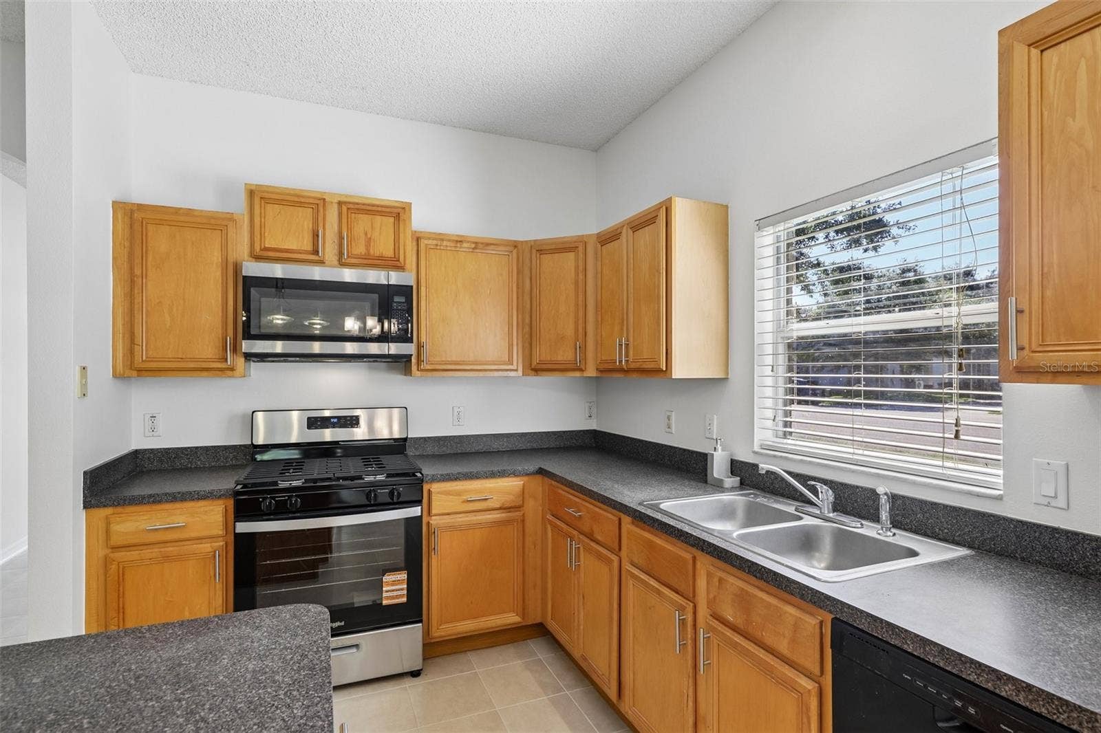 1806 ANNA CATHERINE DRIVE, Orlando, FL 32828 The SPACIOUS KITCHEN features abundant cabinetry and counter space, a gas stove, center island and convenient closet pantry.