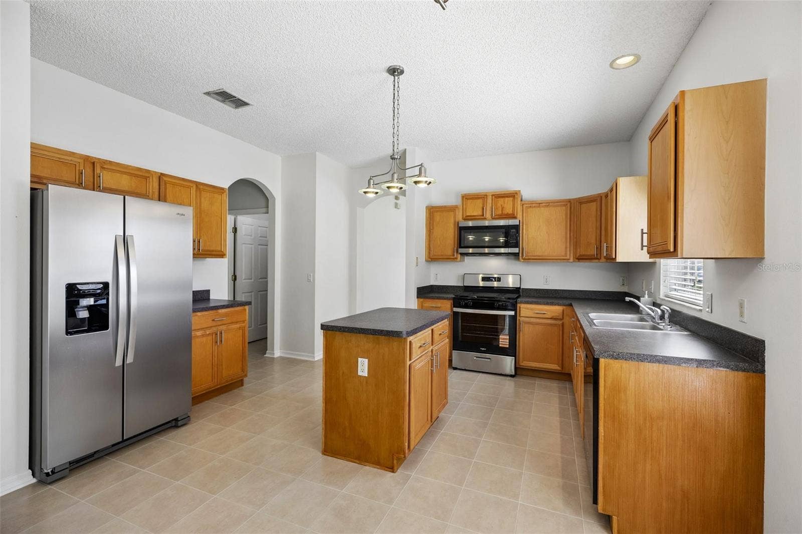 1806 ANNA CATHERINE DRIVE, Orlando, FL 32828 A GRACEFUL ARCHED DOORWAY opens to the Kitchen and Family Room, creating a natural flow between the home's main gathering spaces.
