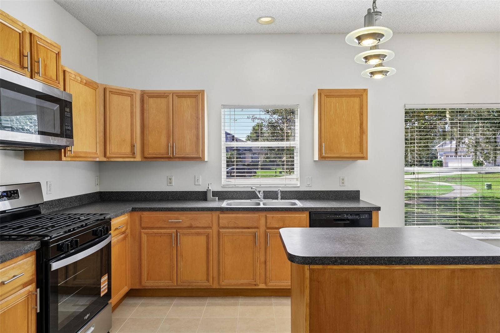 1806 ANNA CATHERINE DRIVE, Orlando, FL 32828 The SPACIOUS KITCHEN features abundant cabinetry and counter space, a gas stove, center island and convenient closet pantry.