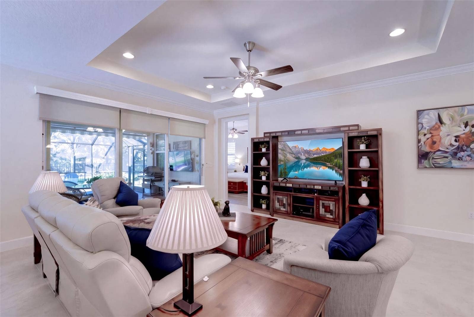 1233 EGGLESTON DRIVE, Deland, FL 32724 15'6" x 18' Great Room w/ tray ceiling, recessed lighting, crown molding & remote controlled shades for the sliding glass doors