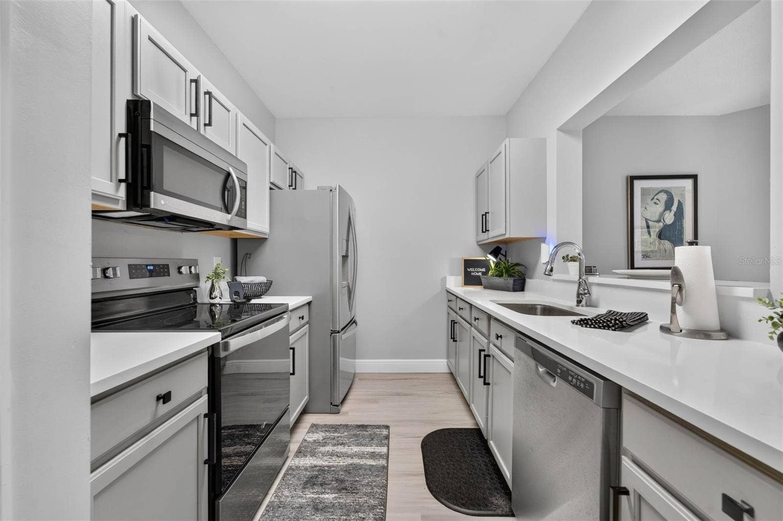 Kitchen with stainless appliances and white stone counters