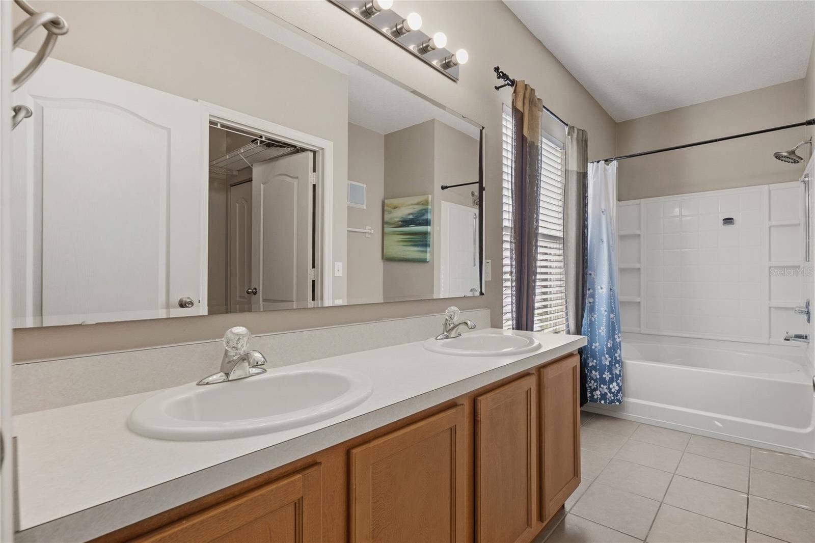 Primary Bathroom with double sinks, tub/shower combo and water closet
