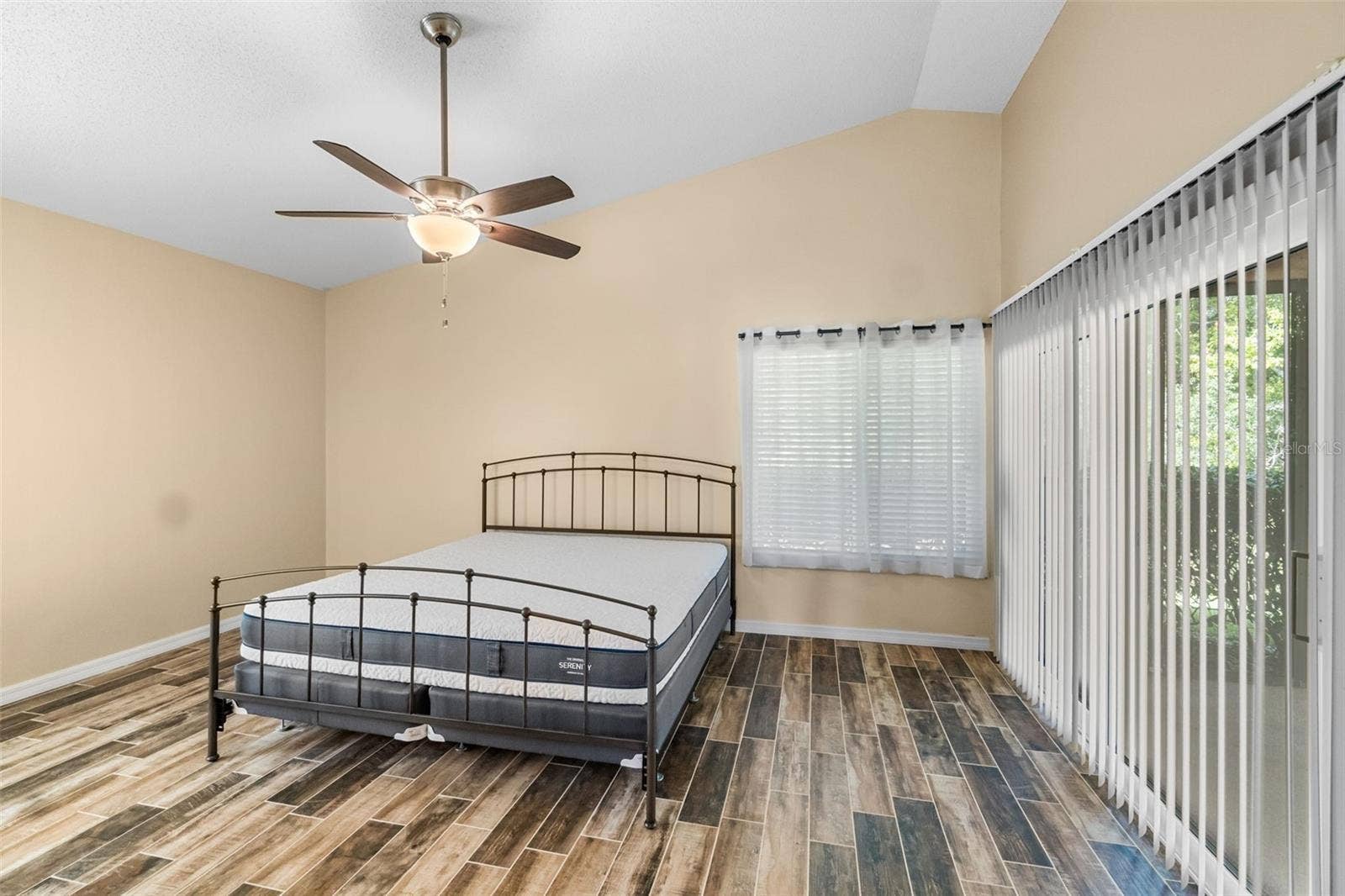 main bedroom with king sized bed and sliders to screened lanai